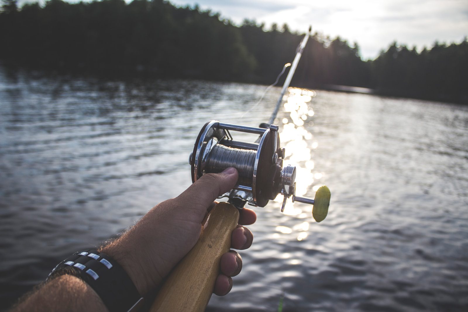 person holding black and silver fishing reel